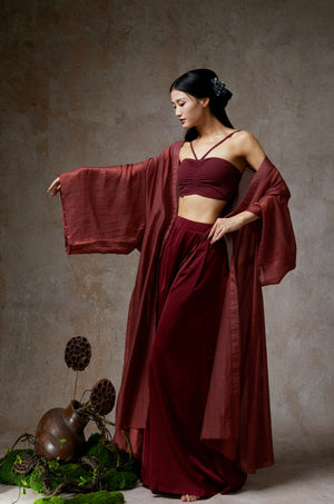 Elegant wine red sheer tencel dance cardigan, model near decorative moss decor