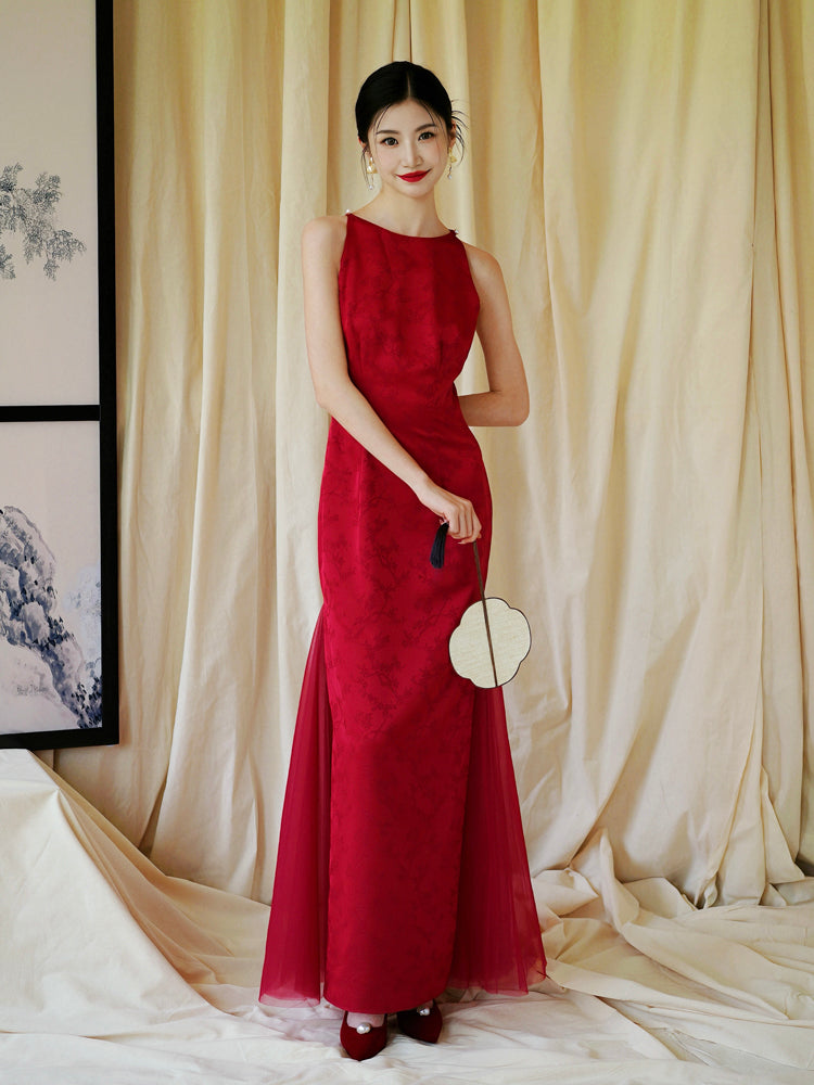 Bride in red cheongsam dress with floral embroidery, styled for wedding or engagement celebrations.