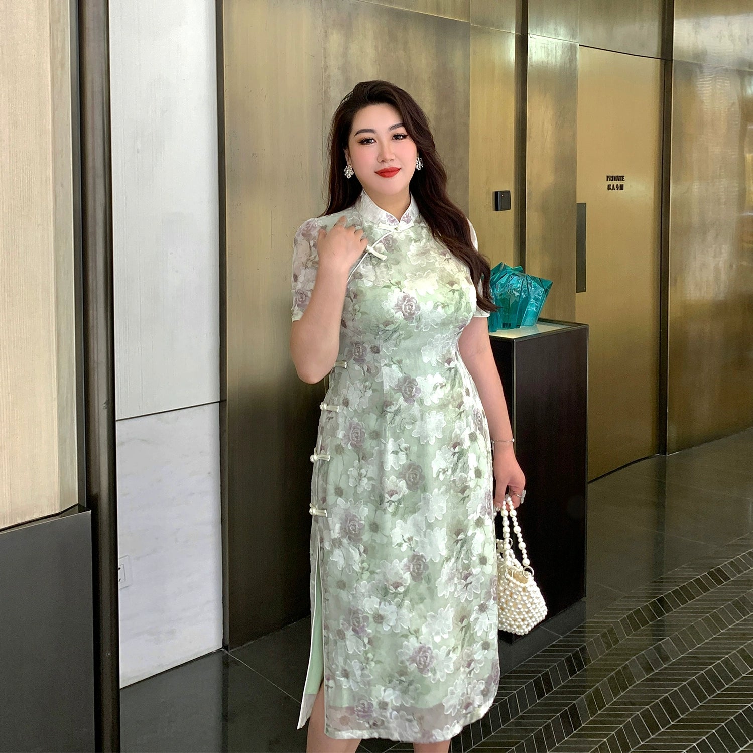 Modern Chinese style green plus size cheongsam/qipao with floral embroidery, short sleeves, and side frog buttons, styled for formal wear.