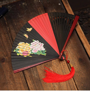 Black and red bamboo folding fan with colorful peony flowers and red tassel. Ideal for Hanfu dance and traditional styling.
