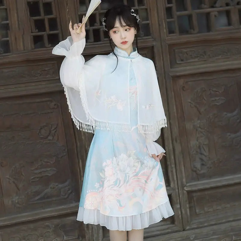Model wearing blue Feihua Hanfu Cheongsam Dress with cape and fan, styled for a classic New Chinese fashion look.