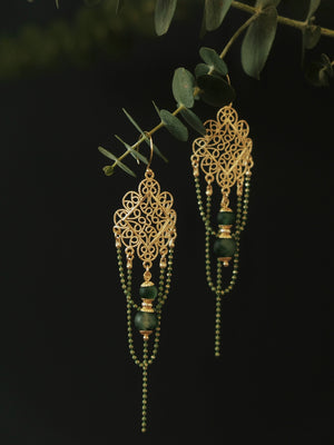 Su Mask Ear Clips - Hanfu Gold Tassel Earrings featuring intricate gold filigree and long green bead strands, hanging on eucalyptus branch.