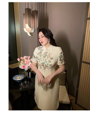 Plus size long cheongsam in champagne with floral embroidery, styled for formal dinners and special occasions.