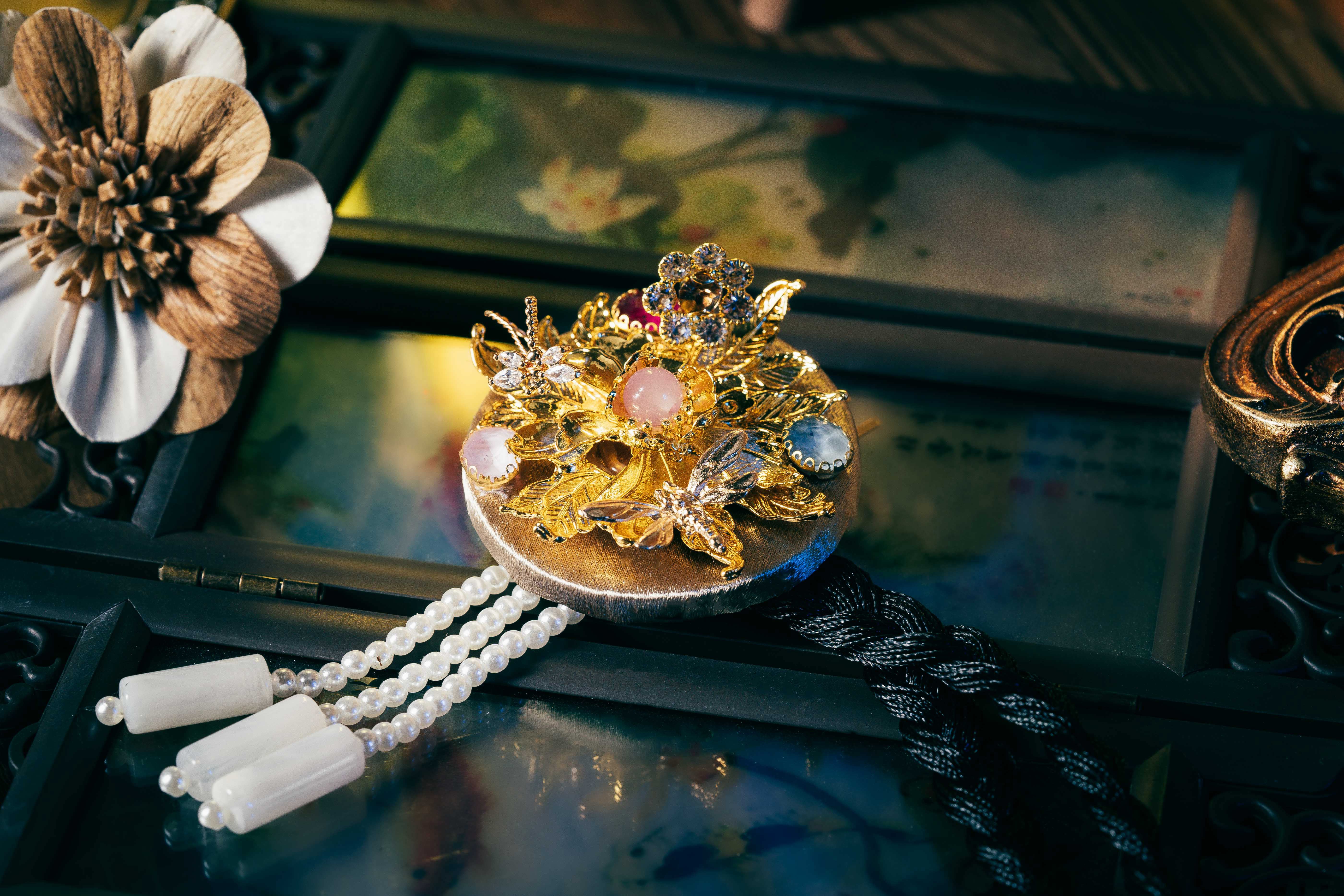 Silver base Korean traditional headgear with intricate gold flowers, colorful stones, and pearl tassels, made with precise cutting.