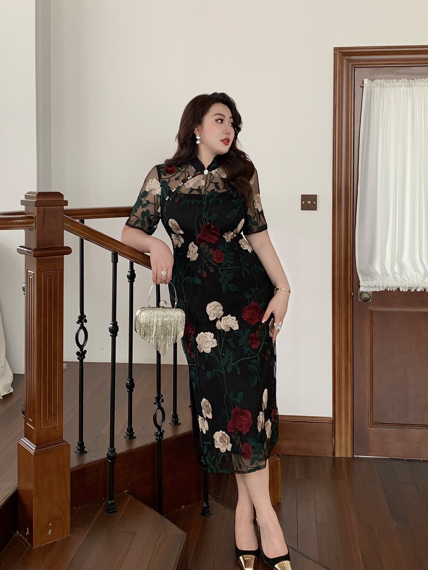 Elegant plus size cheongsam with heavy floral embroidery and lace, styled on staircase for modern China style fashion appeal.