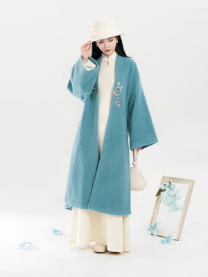 Teal open-front coat over ivory stand-collar dress
