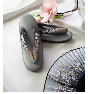 Gray Japanese kimono slippers with white floral embroidery and gradient herringbone straps. A stylish and comfortable choice for formal wear.