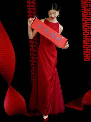 Bride holding red wedding scroll in red cheongsam dress, ideal for engagement or toasting ceremonies.