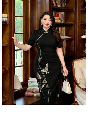 Chinese style embroidered black plus size qipao dress with gold detailing, modeled in a traditional library setting.