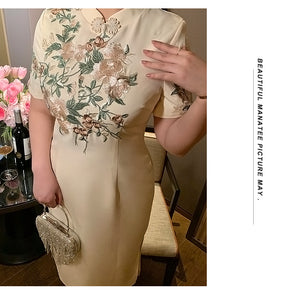 Close-up of floral embroidery on champagne plus size cheongsam, emphasizing craftsmanship and traditional style.