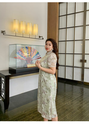 Side view of green plus size cheongsam/qipao with floral embroidery and sheer sleeves, styled for a graceful and elegant appearance.