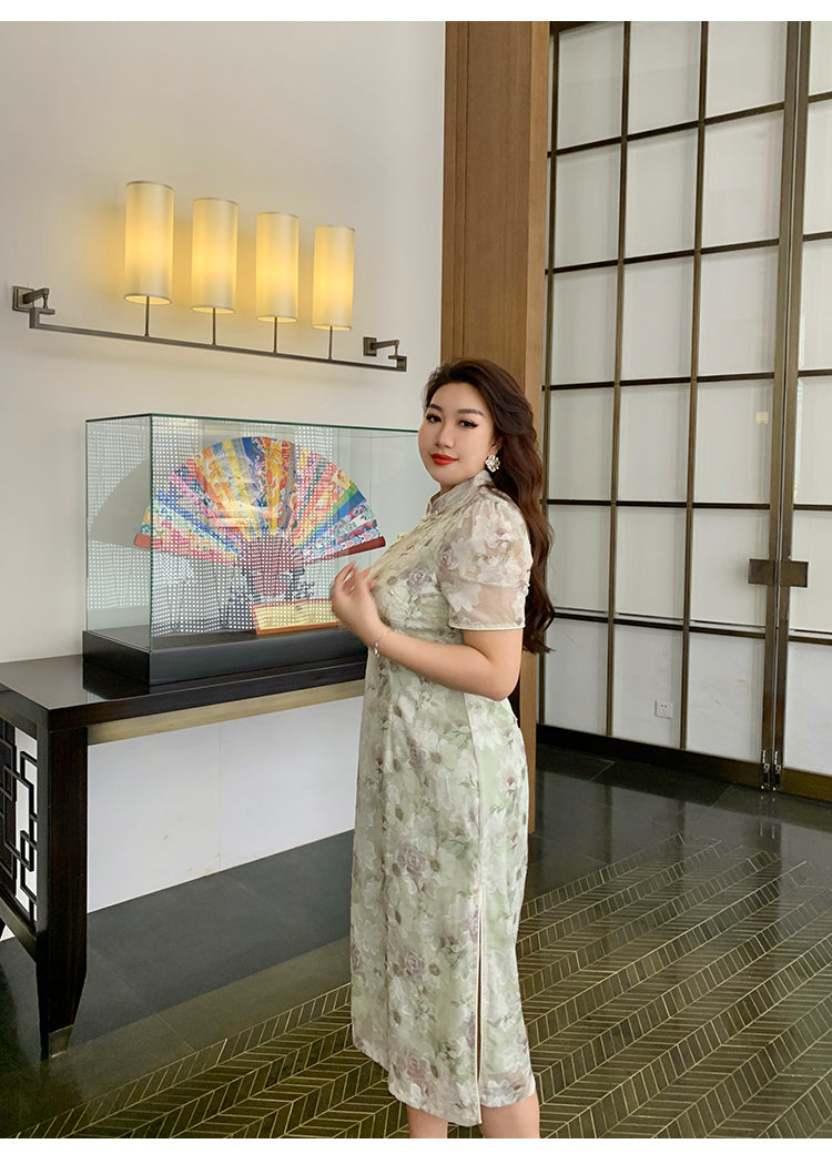 Side view of green plus size cheongsam/qipao with floral embroidery and sheer sleeves, styled for a graceful and elegant appearance.