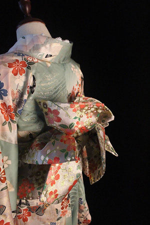 Angled view of Brocade Premium Styling Bow Waist Seal on pastel kimono, featuring vibrant floral brocade and structured bow shape.