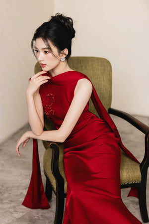 Seated portrait of red Cynthia and Dahlia hand-beaded evening gown