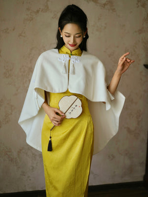 Yellow Cheongsam Bridal Dress styled with a white cape, blending traditional and modern wedding fashion elements.