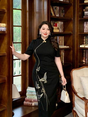Elegant black plus size qipao dress with traditional Chinese embroidery, modeled in a classic wood-paneled library.