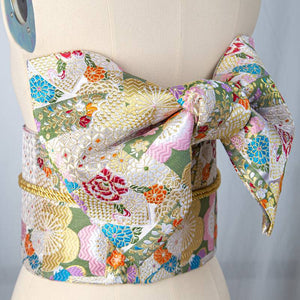 Colorful brocade bow belt with floral and geometric patterns, perfect as a Japanese kimono waist seal for yukata styling and festive wear.