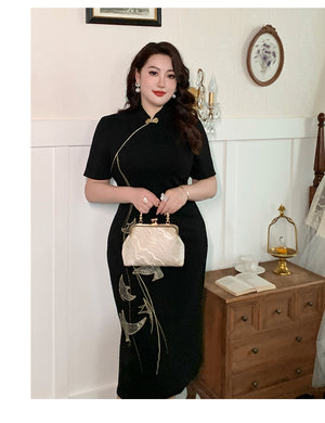 New Chinese style black plus size qipao dress with gold embroidery, accessorized with a vintage handbag in a cozy room.