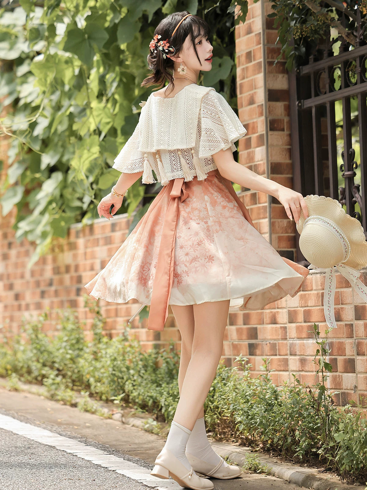 Back view of the ivory lace capelet and flared peach floral skirt