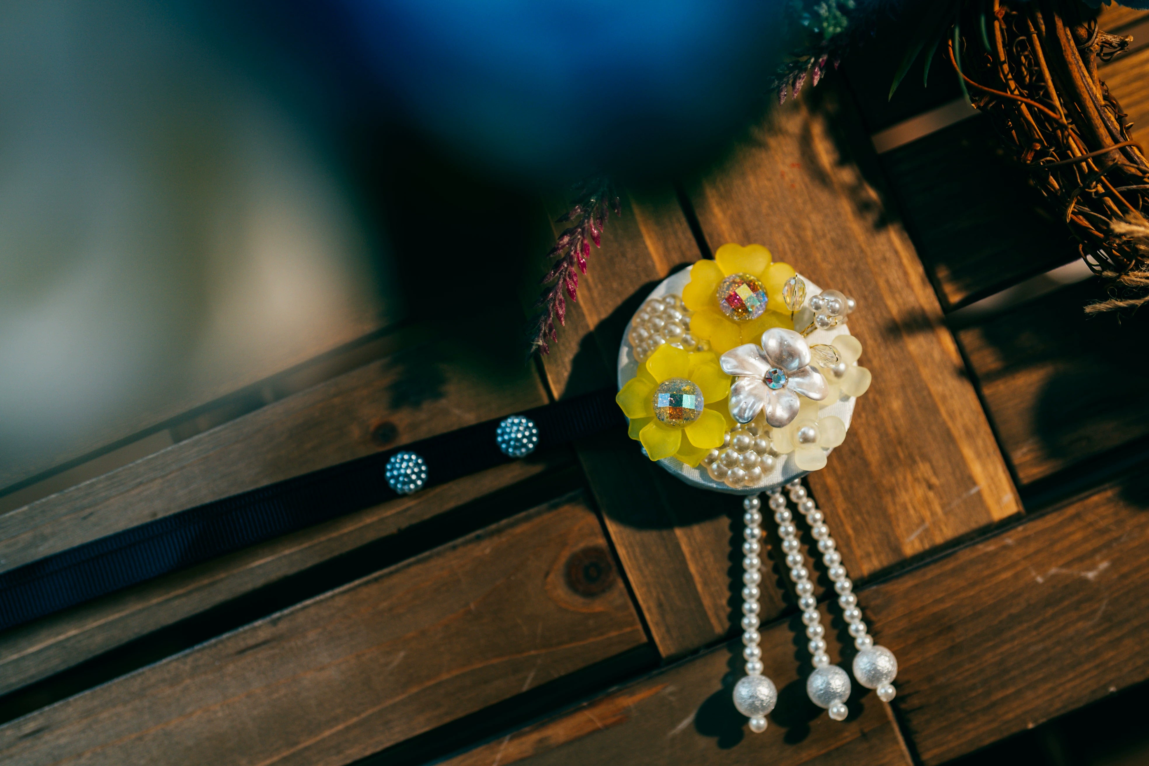 Close-up of A-style Korean traditional headgear with yellow floral design and pearl tassels, ideal for hanbok accessories.