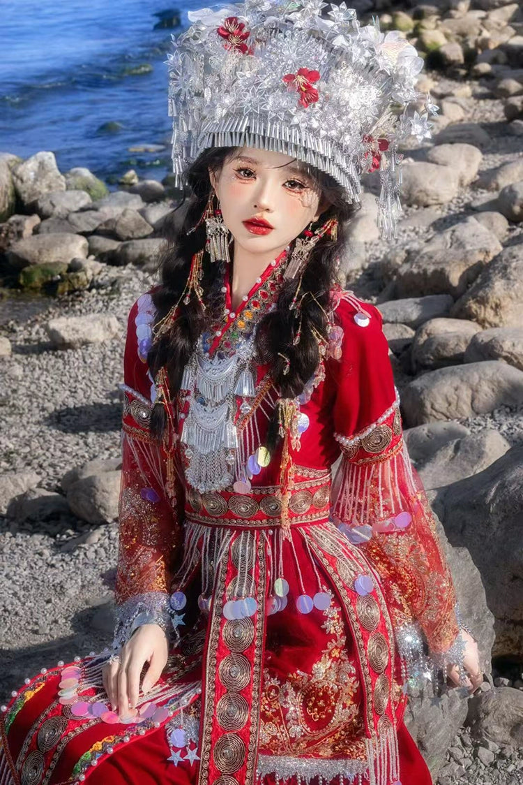 Seated model in red Miao pearl wedding dress with elaborate embroidery and silver adornments, perfect for cultural showcases or weddings.
