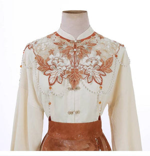 Close-up of embroidered cloud shoulder top with floral and bead embellishments, part of the Maple Leaf Hanfu set.