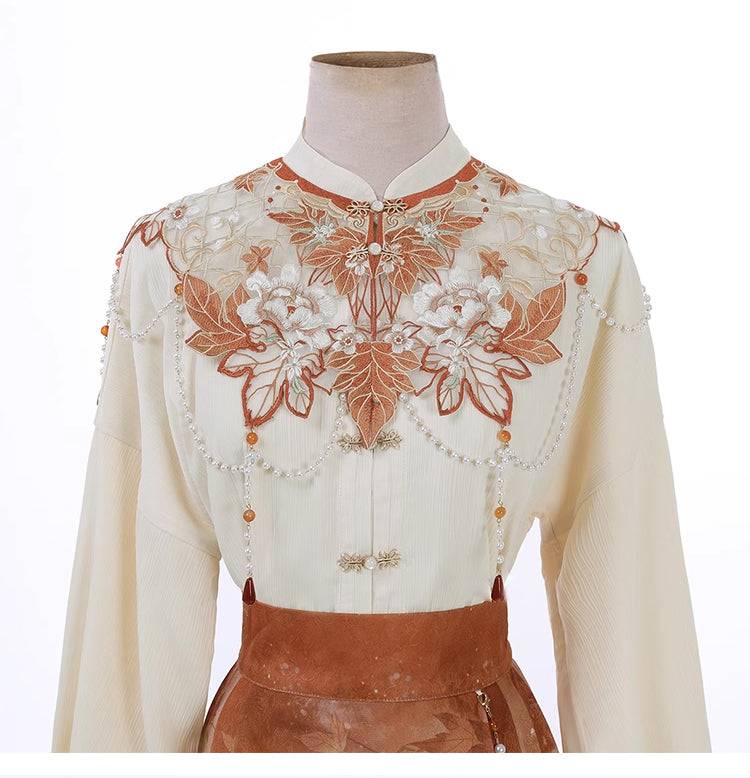 Close-up of embroidered cloud shoulder top with floral and bead embellishments, part of the Maple Leaf Hanfu set.