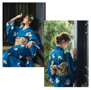 Blue floral yukata styled with a traditional brocade bow belt, showcasing the Japanese kimono waist seal in natural light.
