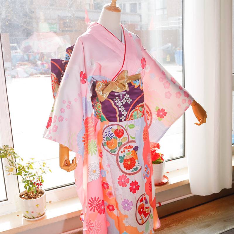 Back view of pink kimono with red and gold big three-leaf bow belt. Swinging sleeves and geisha-style belt bag complete the outfit.