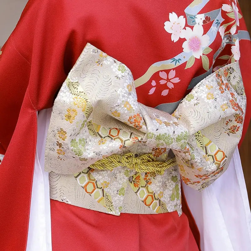 Gold floral brocade bow belt styled with red kimono, ideal for traditional Japanese yukata waist styling and festive fashion shoots.