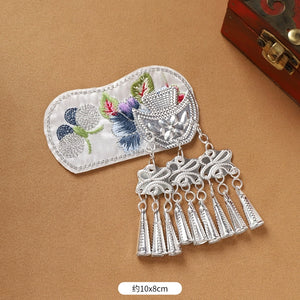 White embroidered Guizhou Miao fridge magnet with silver cone fringe, 10x8cm, handmade ethnic kitchen accessory.