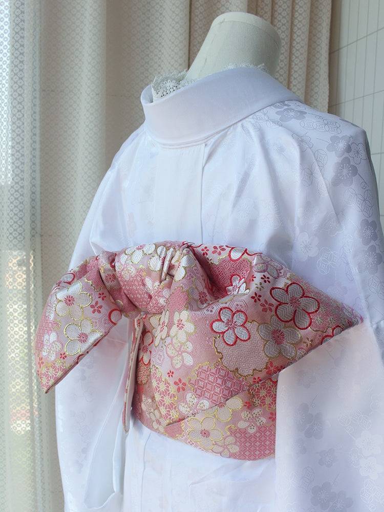 Reversible kimono brocade waist seal with floral bow in pink and gold, styled on white kimono. 120cm length with cotton canvas backing.