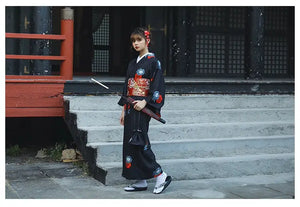 Black Japanese yukata with red and blue floral patterns, accessorized with a red umbrella. A refined choice for Halloween or formal occasions.