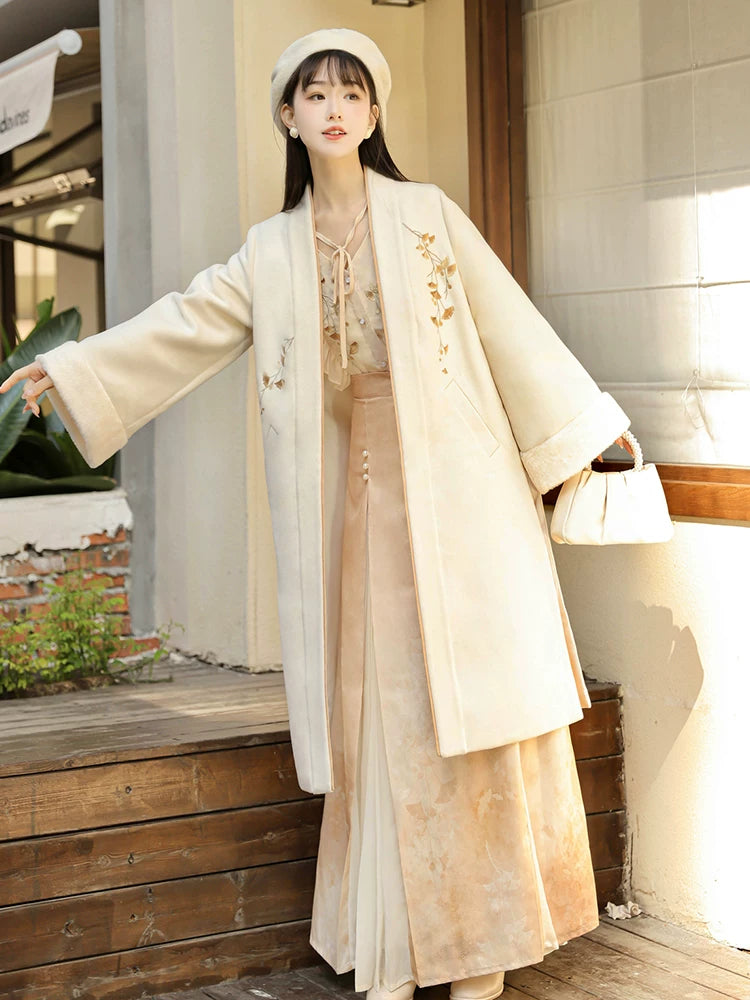 Apricot modern Hanfu coat over a floral blouse and long skirt, with wide sleeves extended