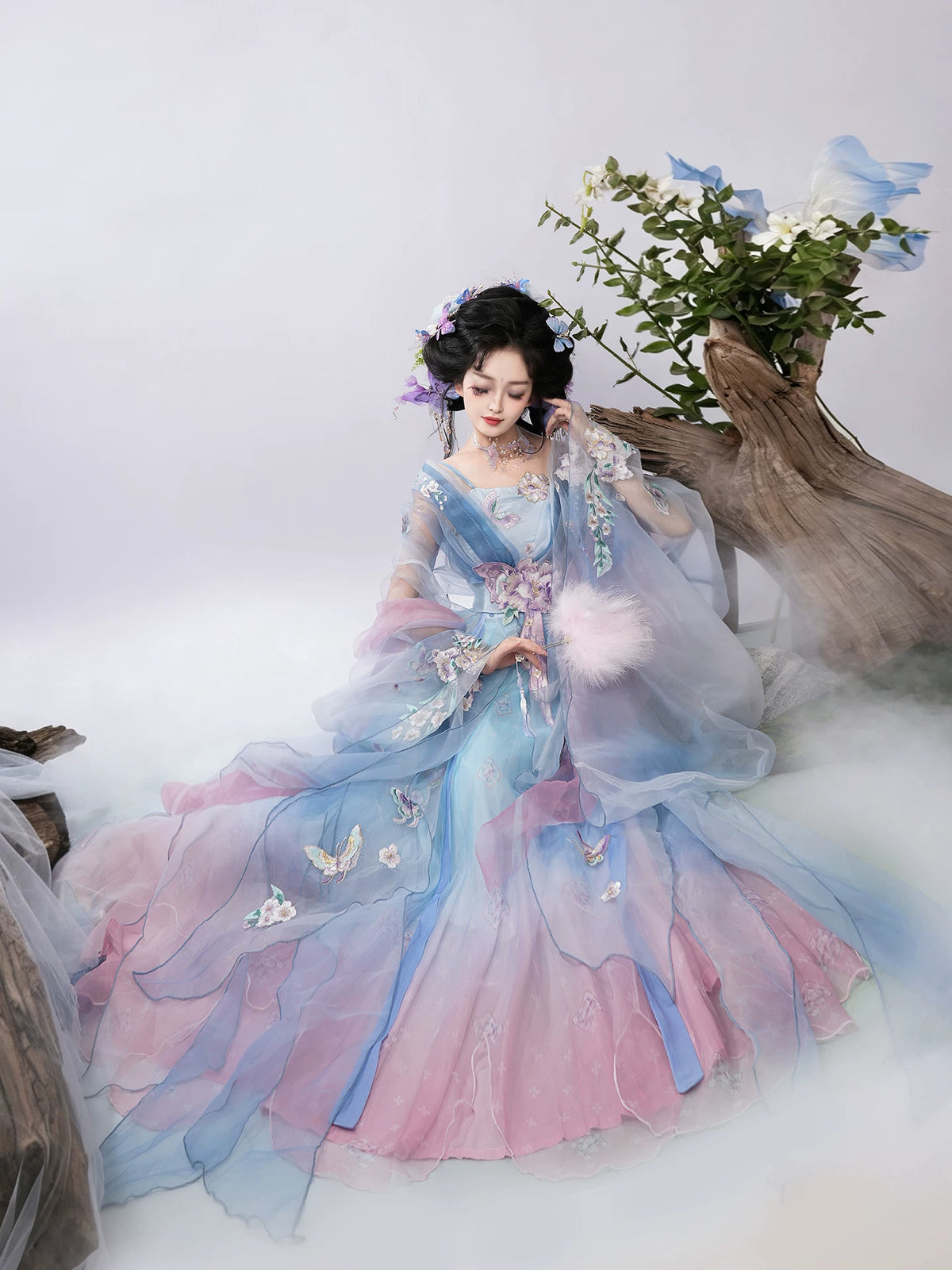 Blue gradient butterfly hanfu with wide skirt seated in studio
