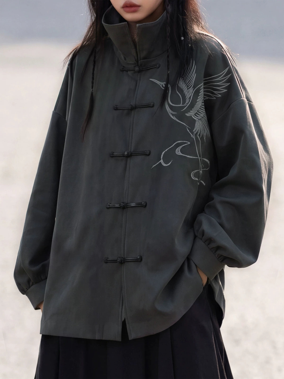 Charcoal Chinese jacket showing a crane motif and frog closures