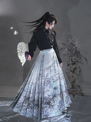 Sky blue Clivia mamian skirt styled with a black shirt, full-length view of botanical motifs and wide pleats.