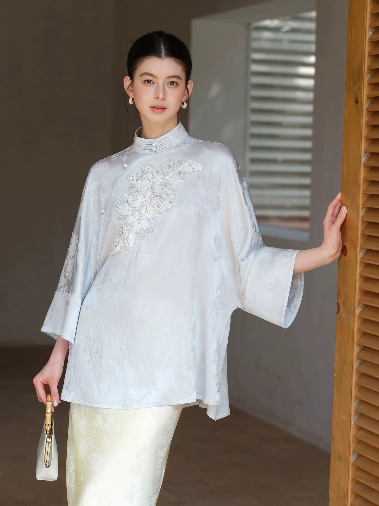 Cloud-Mist Blue embroidered satin top and skirt shown as a polished New Chinese Style outfit, highlighting floral bead embroidery, stand collar and fluid satin silhouette.