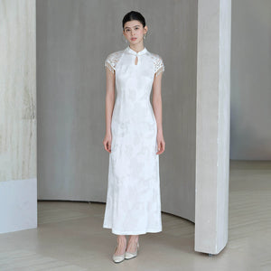 Detailed product image of the Crane White cutwork tassel qipao dress, showing fabric texture, finish and craftsmanship.