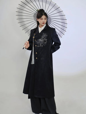 Front view of the black New Chinese style long coat, showing the dragon embroidery, stand collar and flowing longline cut with wide-leg trousers.