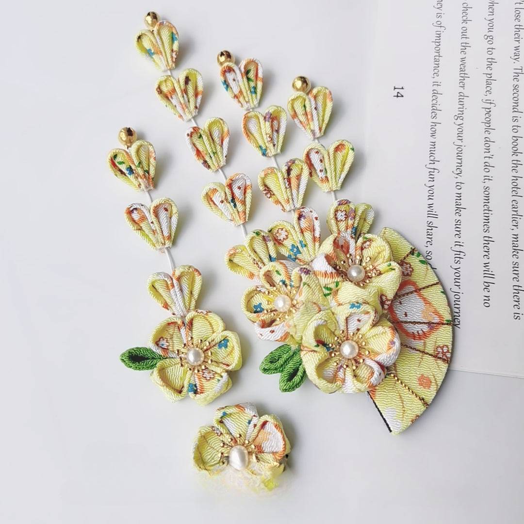 Yellow kimono hair accessory set with floral fan design and petal tassels, accented with pearls and gold bells for elegant styling.