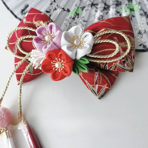 Burgundy kimono hairpin with red, white, and purple cherry blossoms, gold rope bow, and hanging tassels.