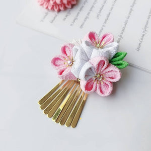 Gold comb hairpin with pink and white cherry blossoms and green leaves, part of the Sakura kimono accessory set.