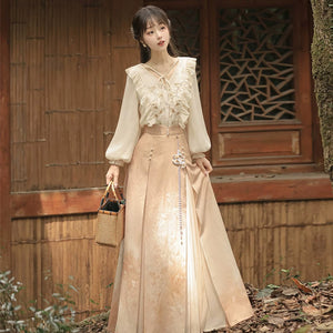 Floral blouse and long apricot skirt worn without the coat, showing the gathered sleeves and waist ornament