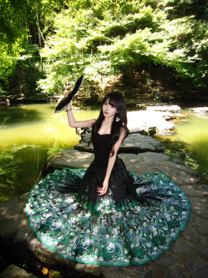 Green brocade mamian skirt with pleats spread in a garden