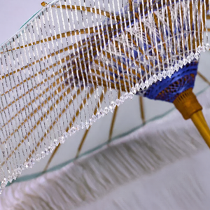 Close-up of clear beaded tassels and woven bamboo hub on the ice-blue oil-paper parasol