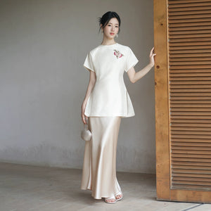 Detailed product image of the Porcelain-Moon mulberry silk top and champagne skirt, showing fabric texture, finish and craftsmanship.