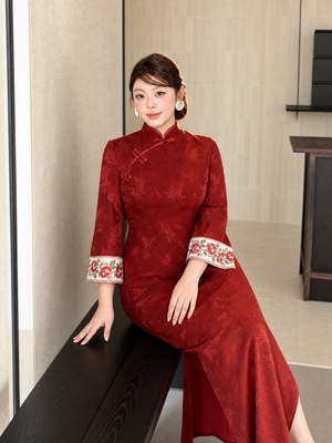 Red Wall Butterfly plus size qipao seated view showing drape and embroidered cuffs