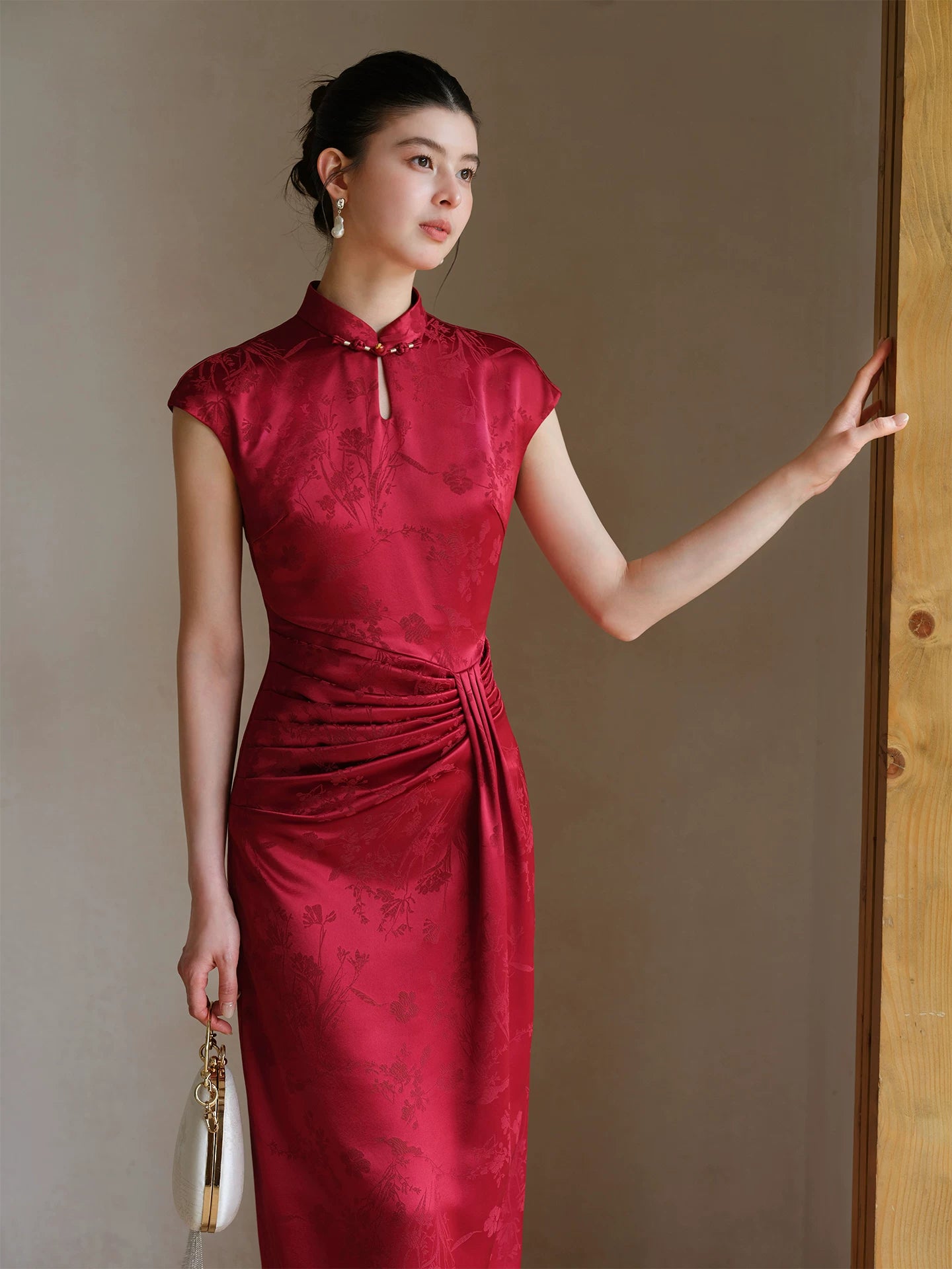 Front styling view of the Ruby Red acetate jacquard pleated qipao dress, with acetate jacquard, sculpted pleats and elegant Chinese dress silhouette.