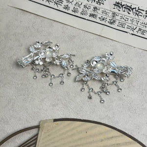 Silver-tone floral hair clips displayed flat